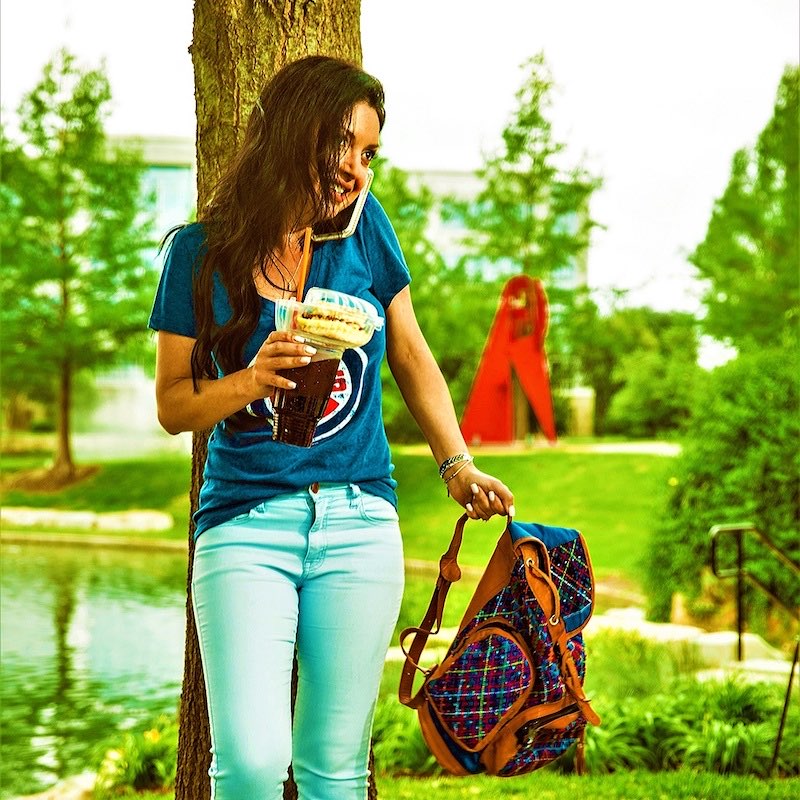 Girl in Cubs shirt leaning against tree